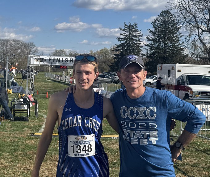 Travis Furmanski in cross country gear with coach Brandon Risser after winning gold medal in PIAA championship race.