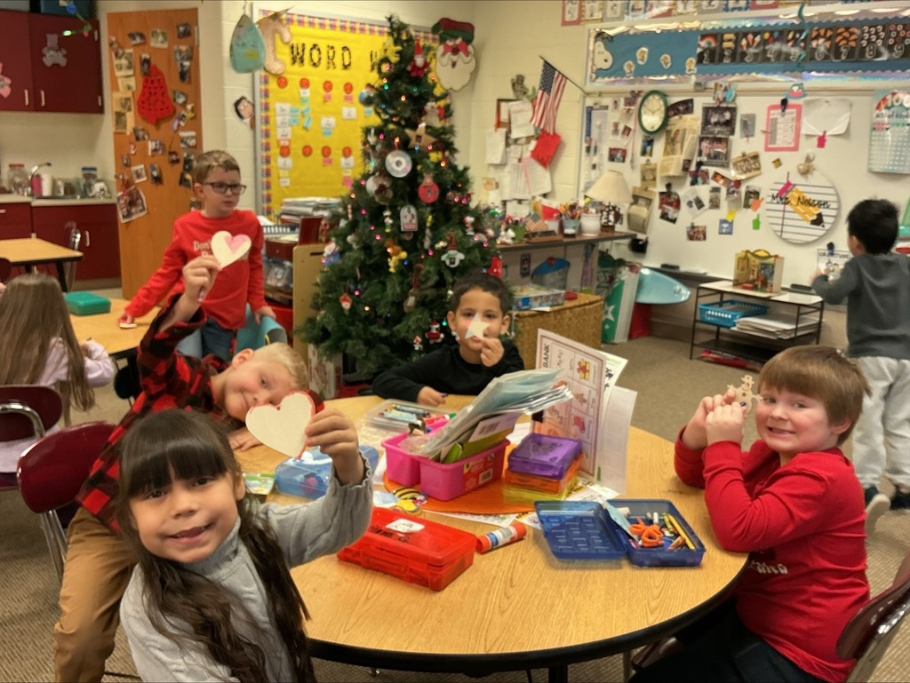 Kindergarten students making holiday cut-out ornaments at a round table