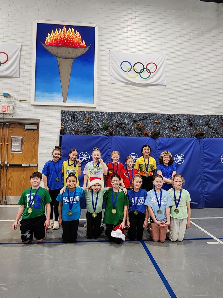 Fifteen fith grade students posing in the fym with "Cornwall Olympics" gold medals around their necks