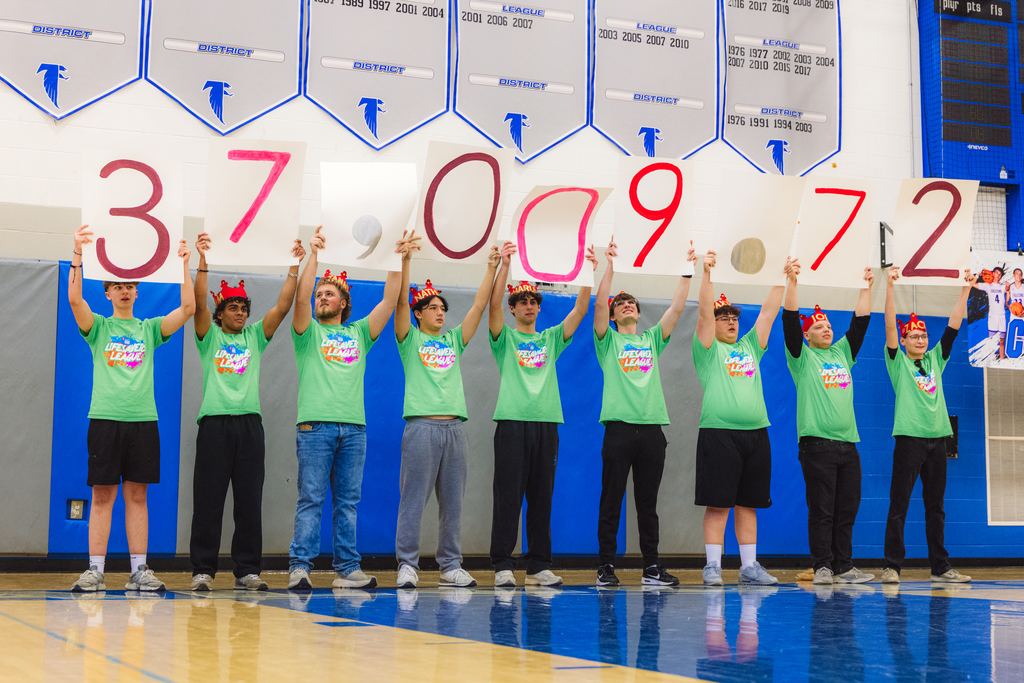 12 high school senior boys hold signs about their heads that say $37,009.72