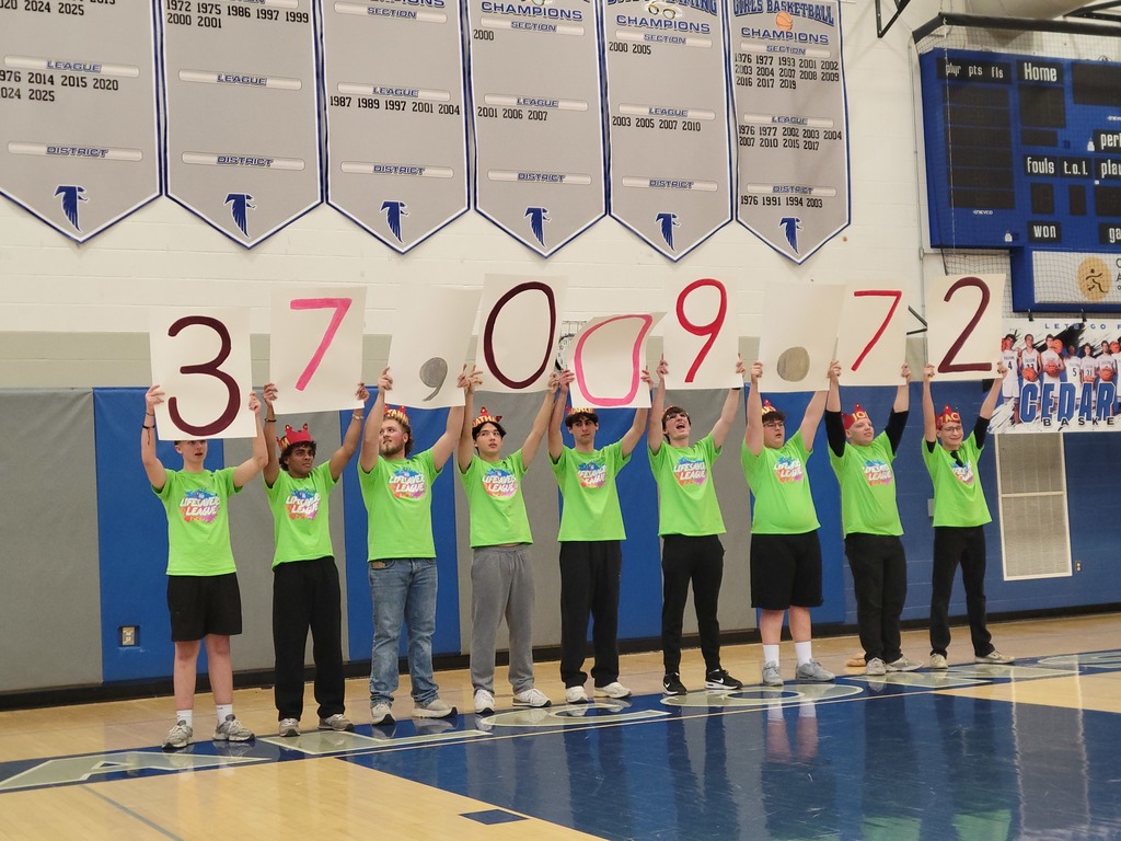 Nine high school boys stand in a line holdings signs above their heards that read $37,009.72