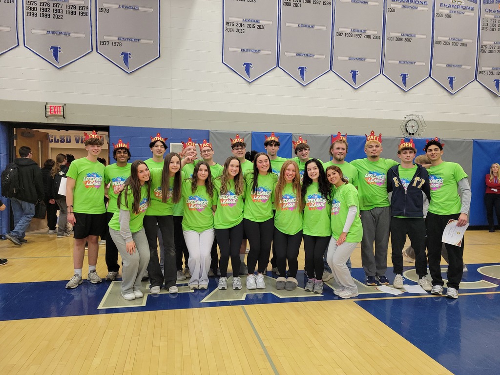 Twelve high school boys and eight high school girls pose wearing Lifesaver League green t-shirts