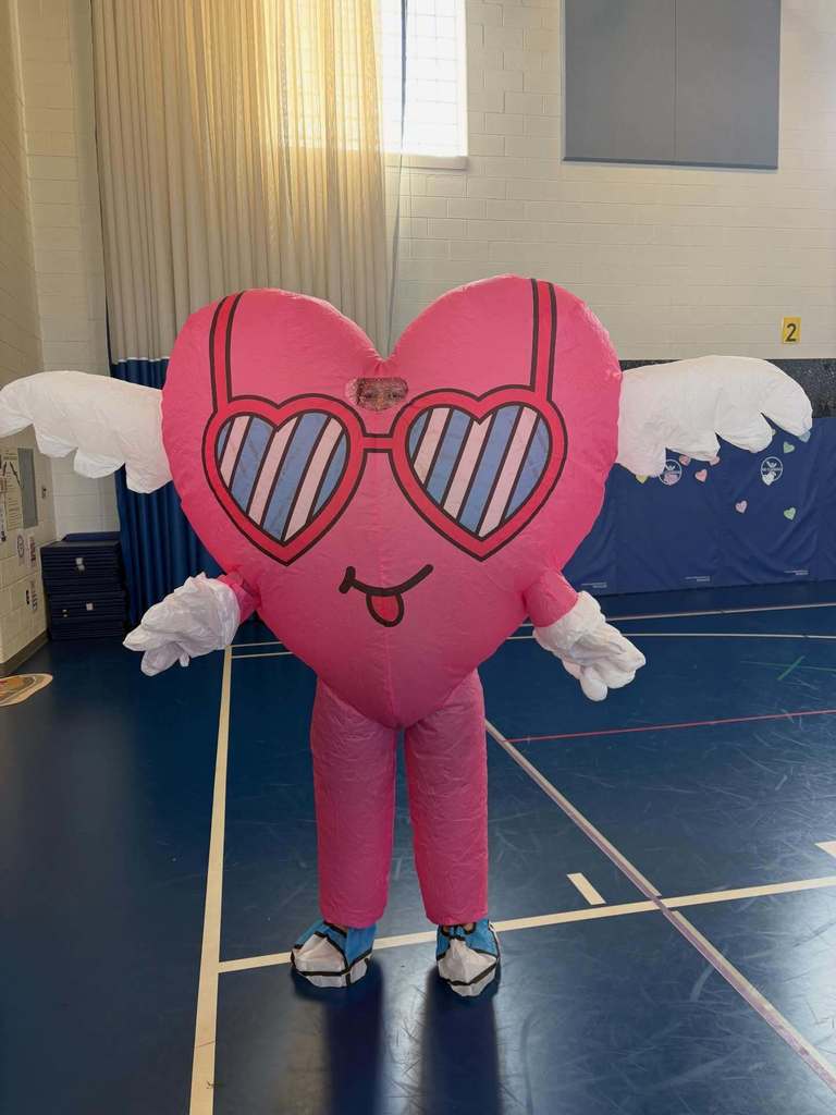 person dressed in a pink heart costume complete with wings and tennis shoes