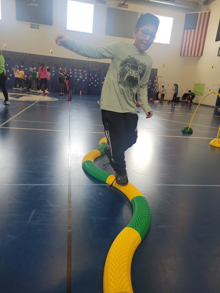 elementary school boy balances while walking on the floor balance "snake" beam