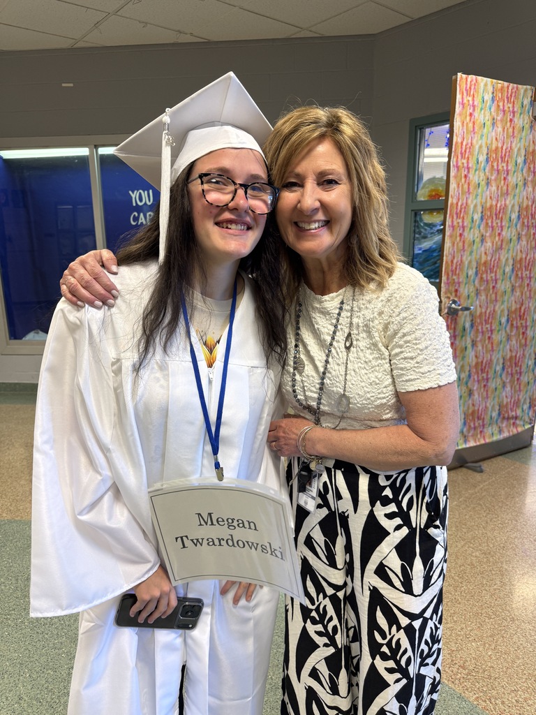 A graduating senior poses for a photo with her middle school art teacher