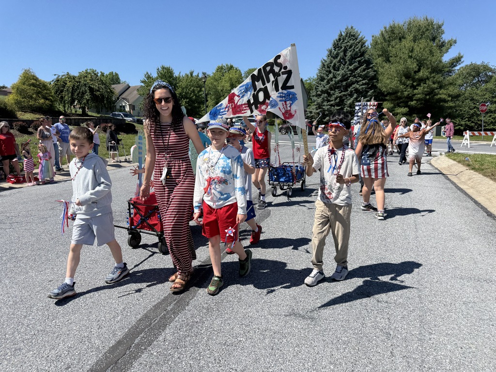 Students and their teacher walk during the parade