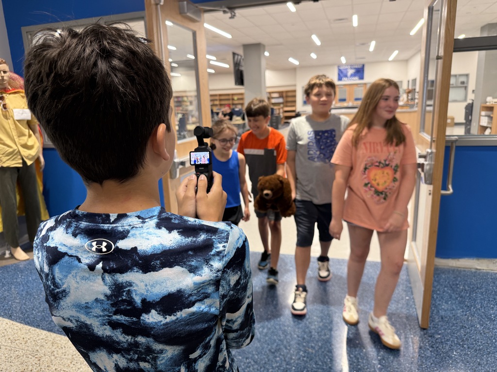 A student films his teammates in a scene for their short video
