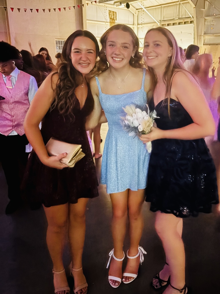 Three students in dresses pose for a photo during the Homecoming Dance.