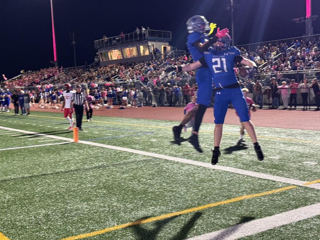Members of the Cedar Crest High School football team celebrate in the end zone after a touchdown.