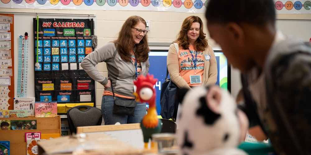Two teachers observe students in a pre-Kindergarten classroom