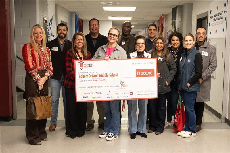 CCEF Board members and school leaders granting a check to Driscoll Middle School teacher