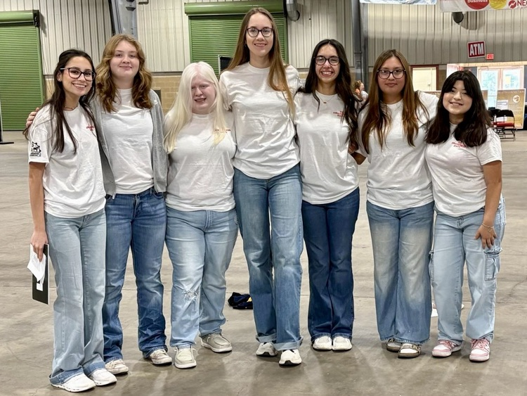 Four Carroll FFA members in official blue corduroy jackets pose in front of a Texas A&M University–Kingsville College of Agriculture and Natural Resources banner after competing at the Hoggie LDE Invitational Contest.