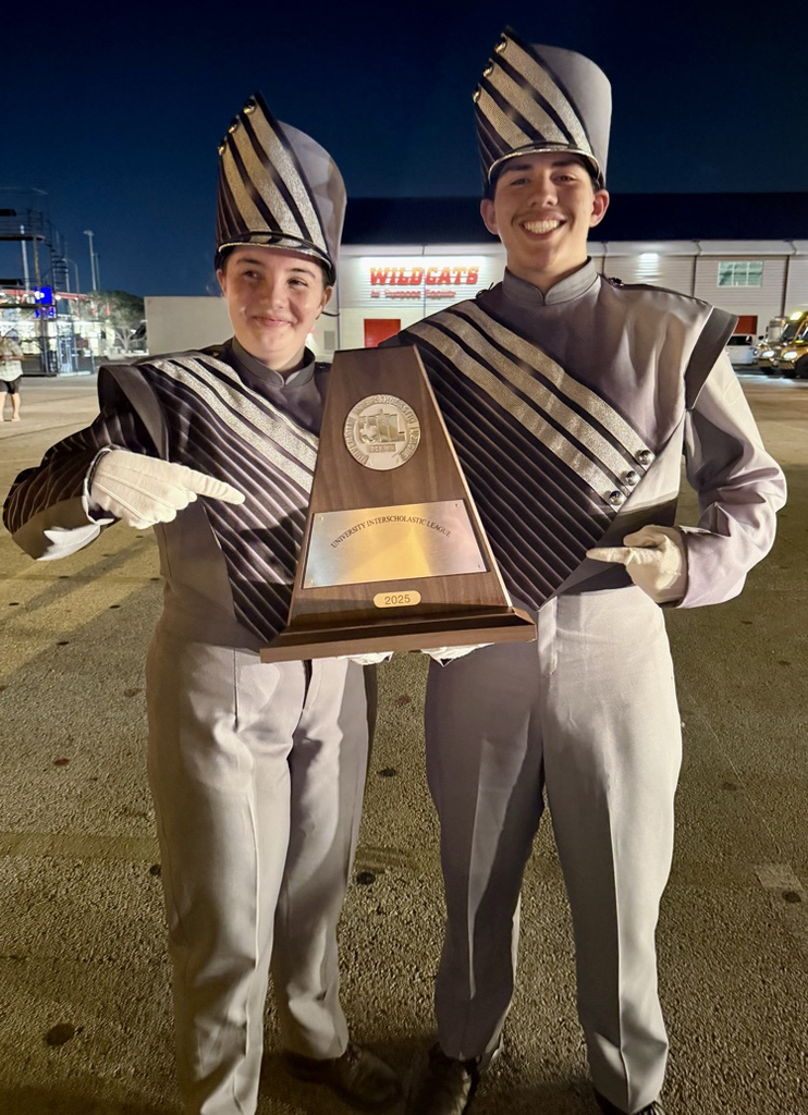 Alt text: Two Carroll Tiger Band members smiling and holding a UIL trophy after earning straight 1’s at Region.