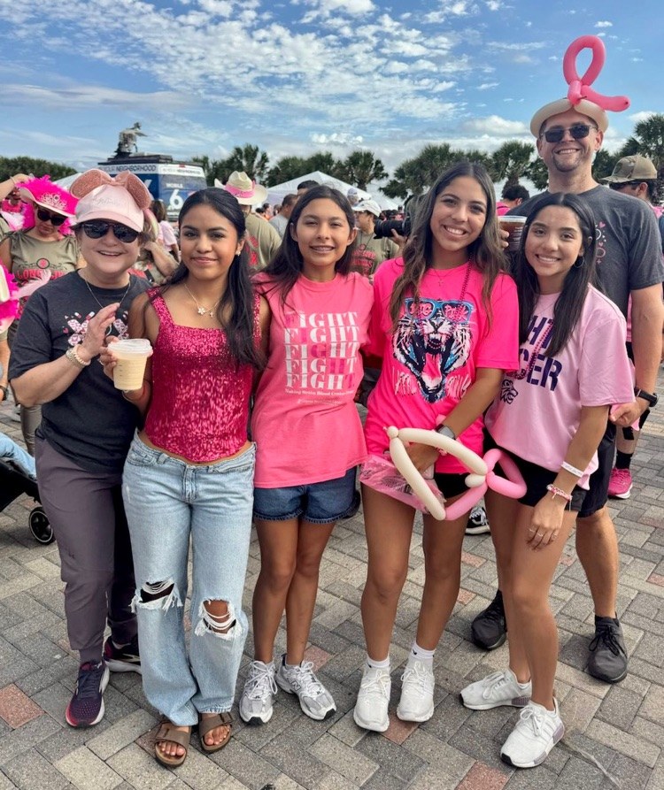 Alt Text: Group of Carroll students and staff in pink shirts smiling at the Making Strides walk event.