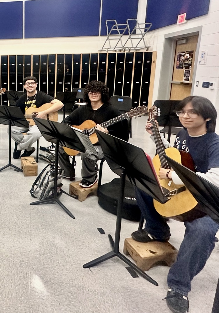 Students in advanced guitar class practicing together with guitars and music stands for the upcoming Winter Holiday Concert.