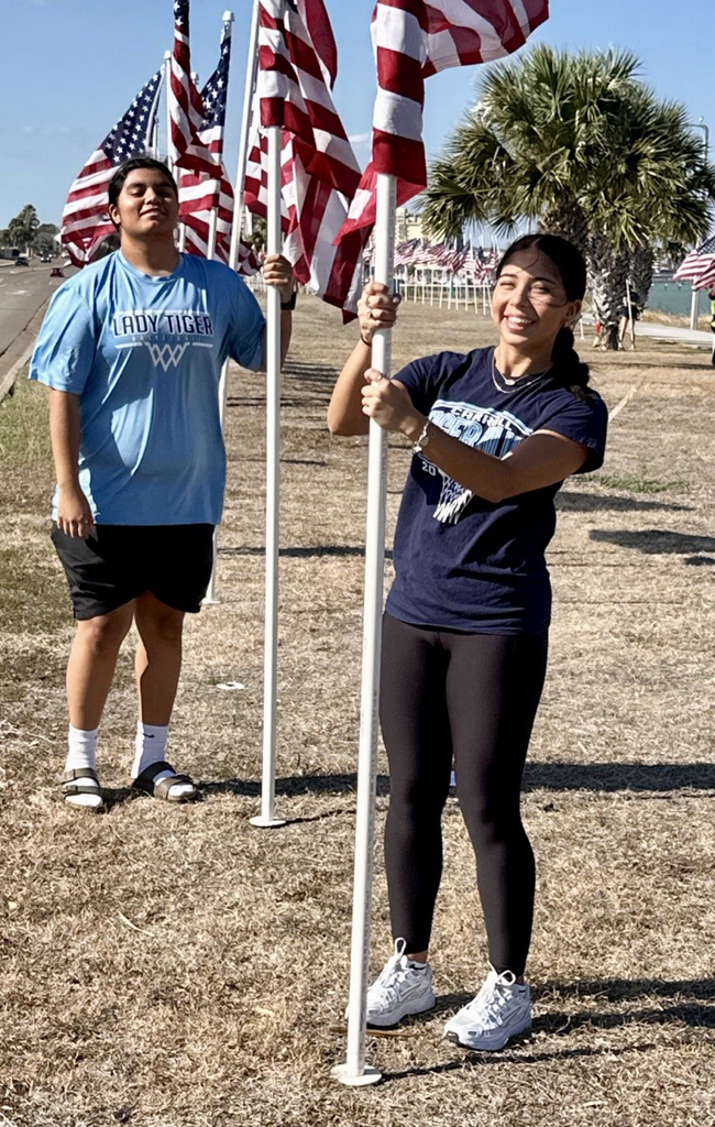 Students from Carroll’s girls basketball team help remove American flags from the Flags for Heroes display by the bay.