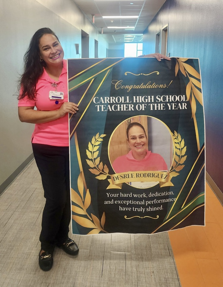 “Teacher holding flowers and posing with a Teacher of the Year banner alongside students and staff.” 