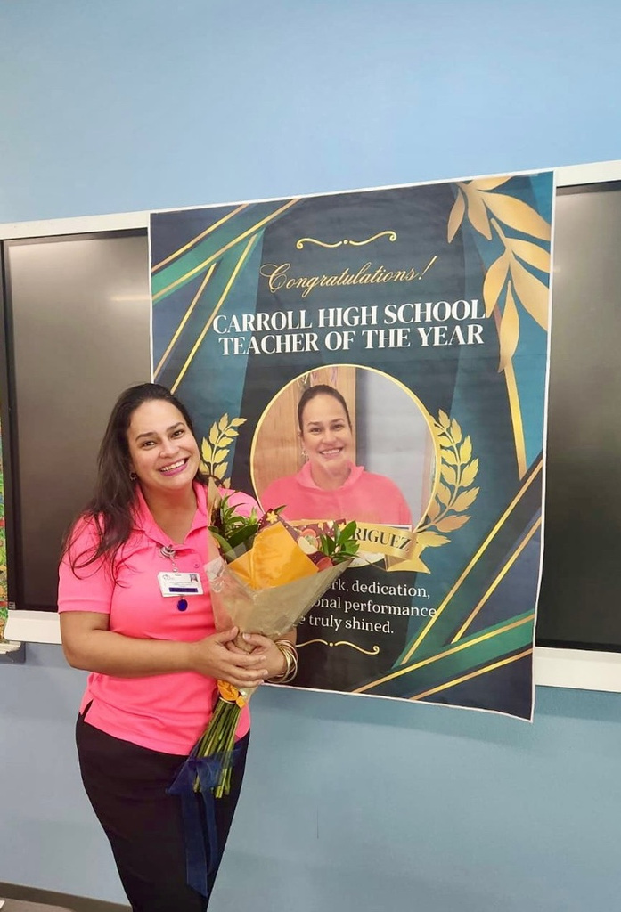 “Teacher holding flowers and posing with a Teacher of the Year banner alongside students and staff.” 
