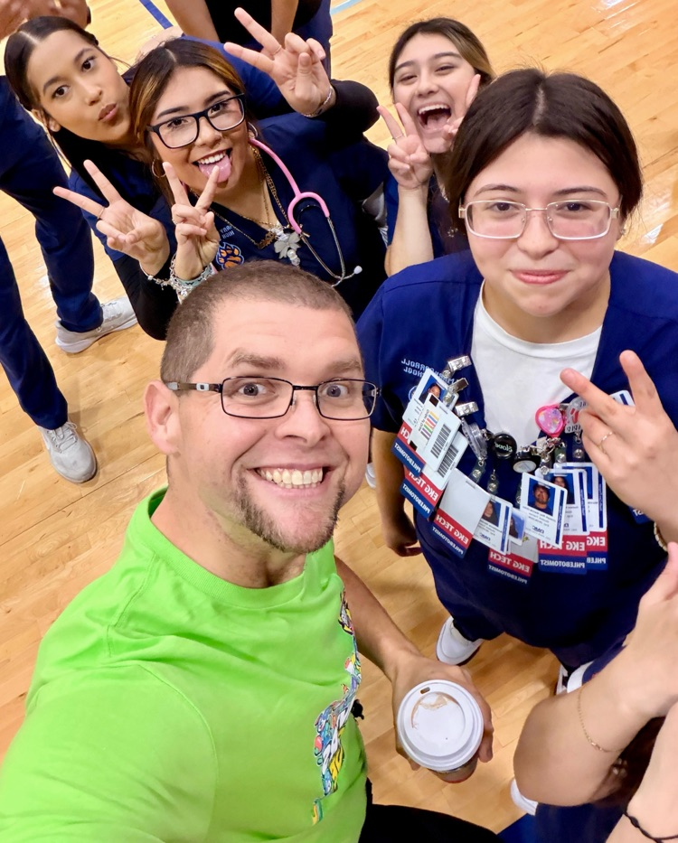 Alt text: Students practicing CPR on mannequins in the gym with Health Science helpers.