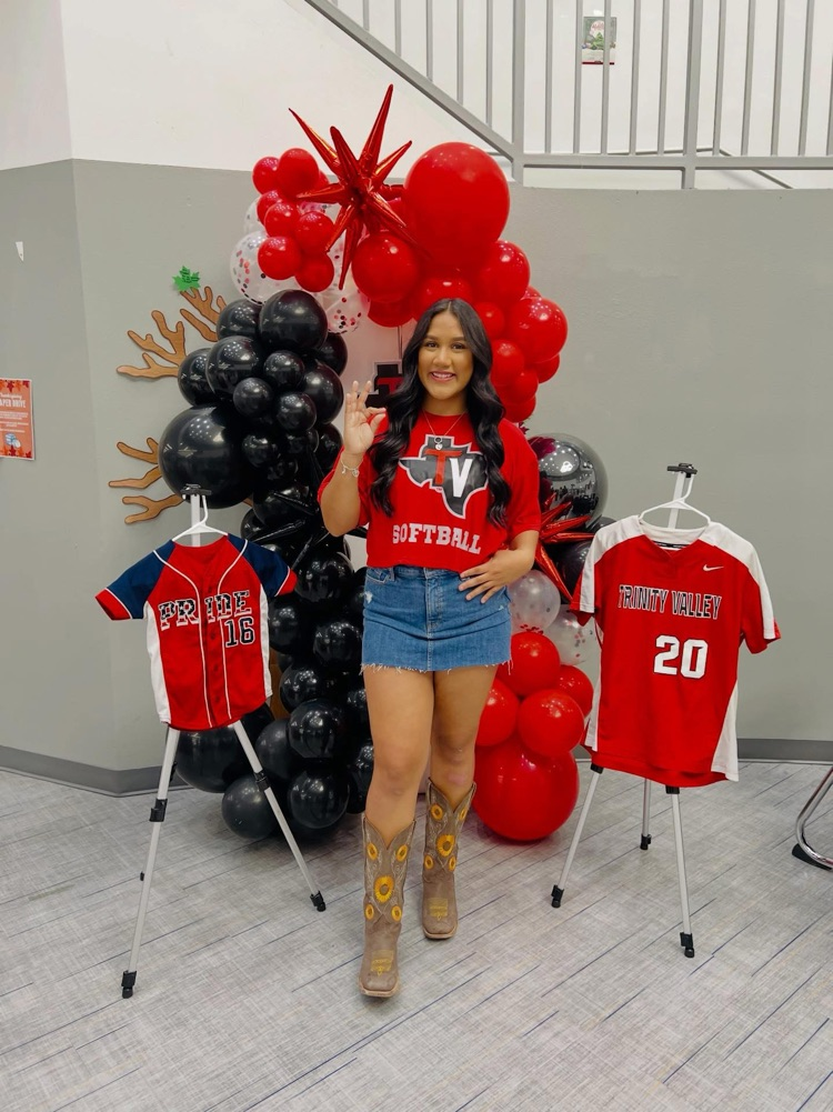 Alt Text: Talina Valdez sits at a signing table with her family during