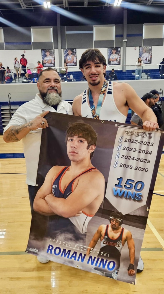 Carroll High School wrestling team poses together in front of a large Tigers backdrop, holding first-place team trophies after winning the Rumble in the Jungle tournament. 
