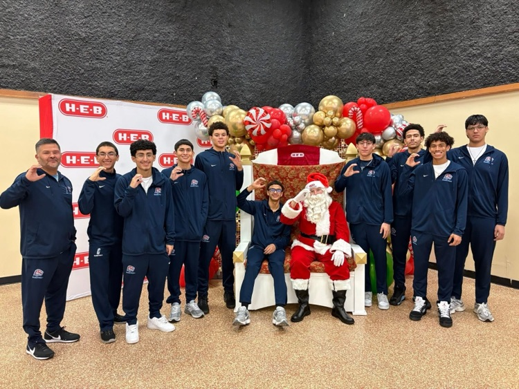Carroll High School student-athletes wearing volunteer aprons serve meals and help at a community dinner event.