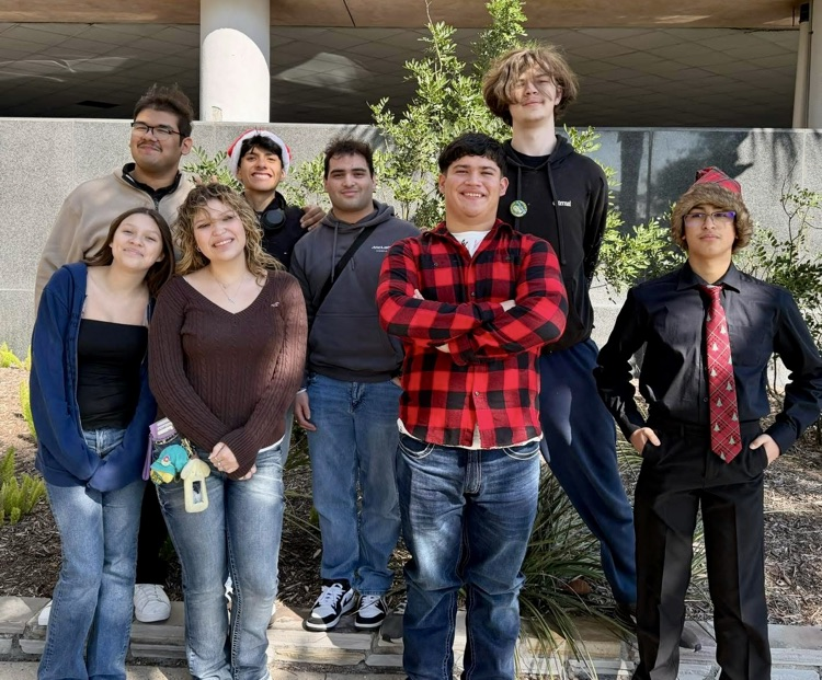 Carroll tuba students performing with a large group of tubists during a holiday Tuba Christmas concert indoors.