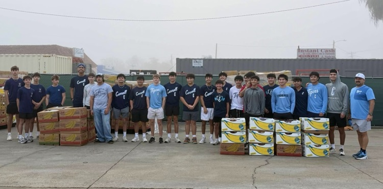 Carroll High School baseball players unloading boxes of food while volunteering in the community. 
