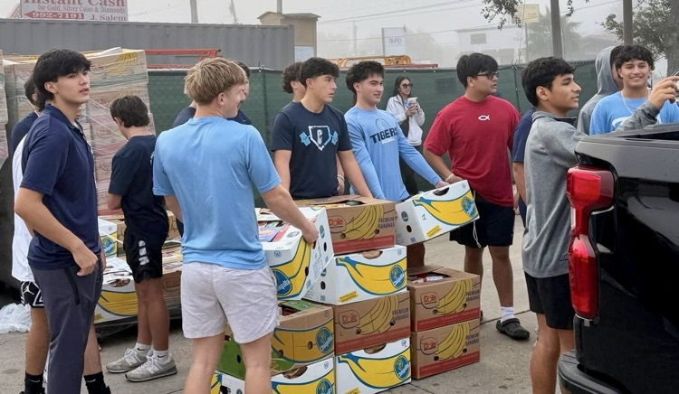 Carroll High School baseball players unloading boxes of food while volunteering in the community. 