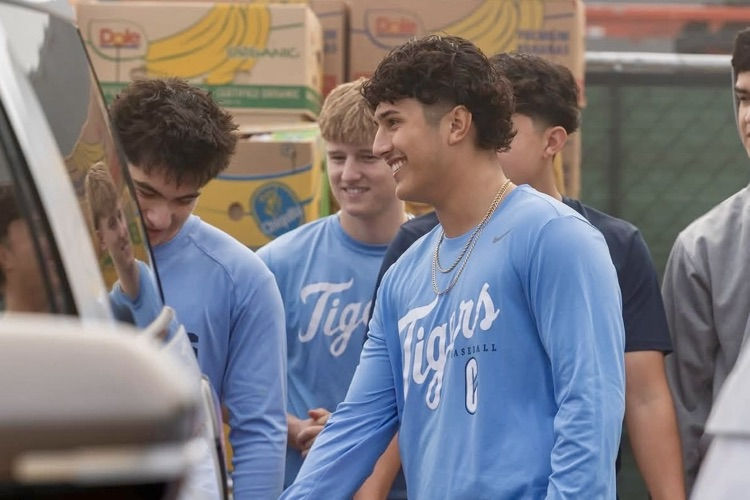 Carroll High School baseball players unloading boxes of food while volunteering in the community. 