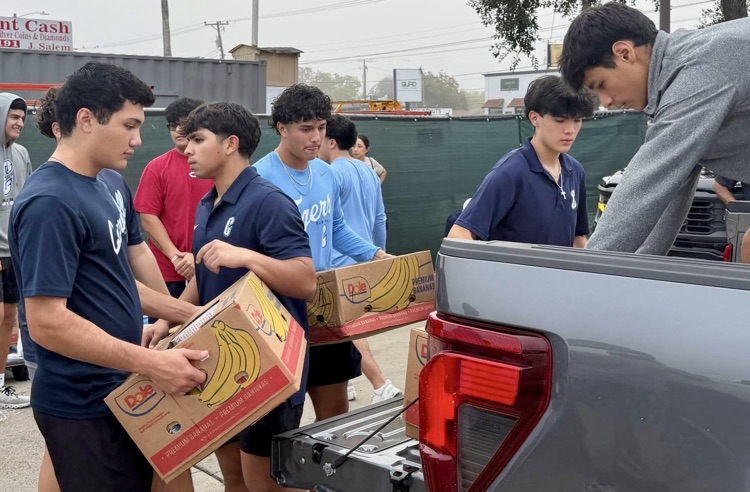 Carroll High School baseball players unloading boxes of food while volunteering in the community. 