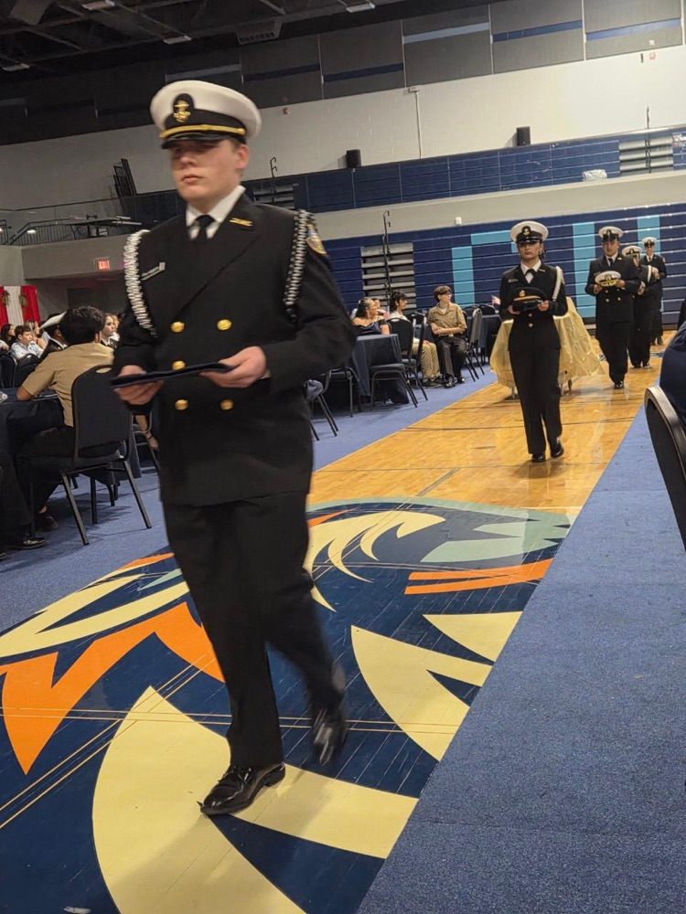 ⸻ Short alt text (one): ROTC cadets in formal uniform during the Military Ball inside the school gym.
