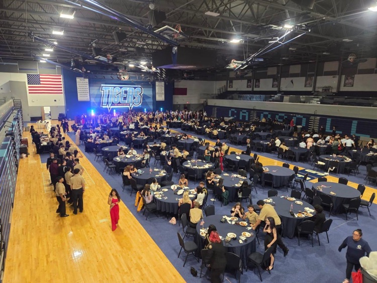 ⸻ Short alt text (one): ROTC cadets in formal uniform during the Military Ball inside the school gym.