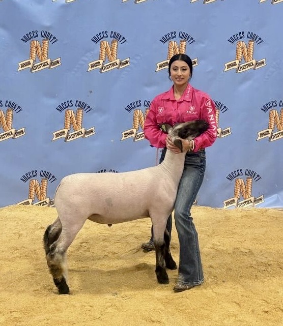 Student poses with her lamb at the Nueces County Junior Livestock Show.