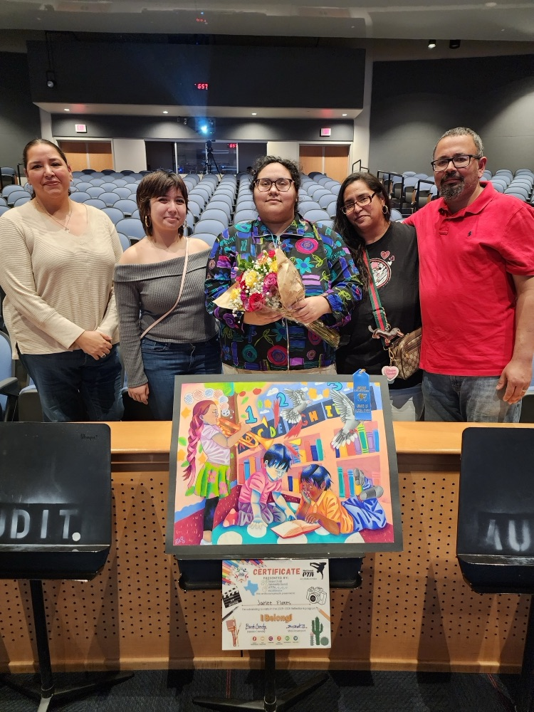 Student holds a colorful award-winning artwork alongside family members in an auditorium, celebrating advancement to the state PTA Reflections contest.