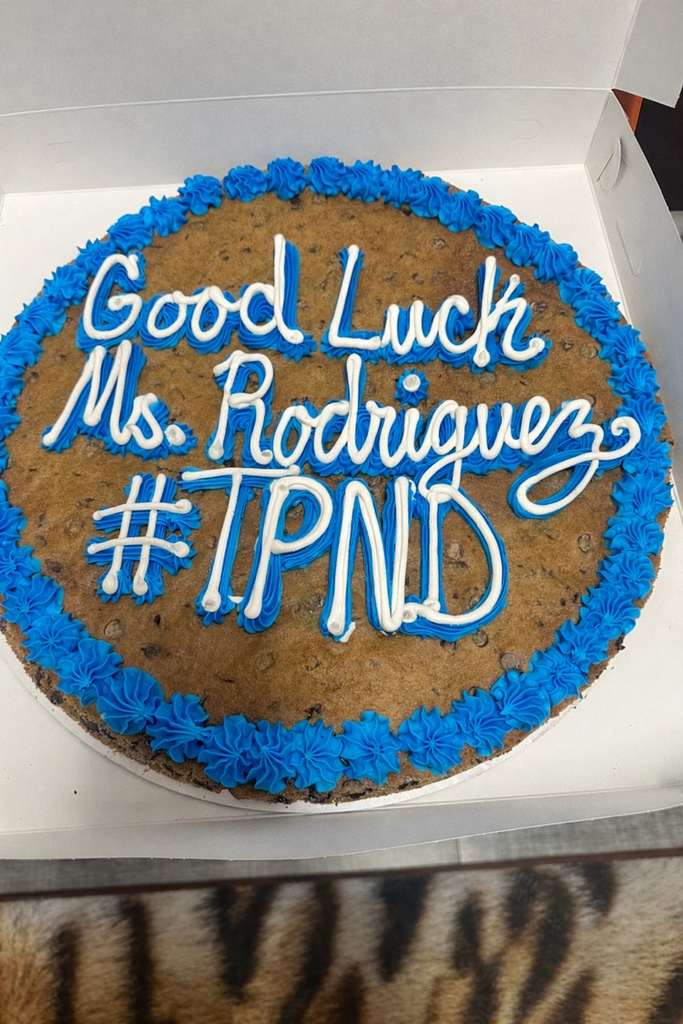 Staff celebrating Señora Rodriguez with balloons and a cookie cake in her classroom. 🎉🍪💙