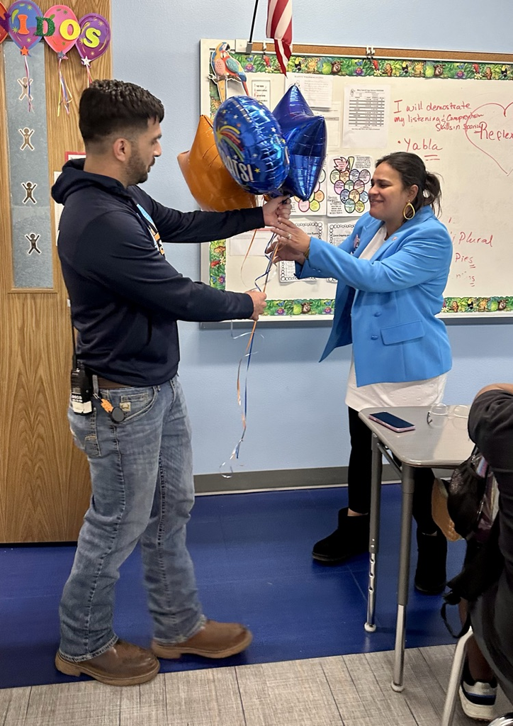 Staff celebrating Señora Rodriguez with balloons and a cookie cake in her classroom. 🎉🍪💙