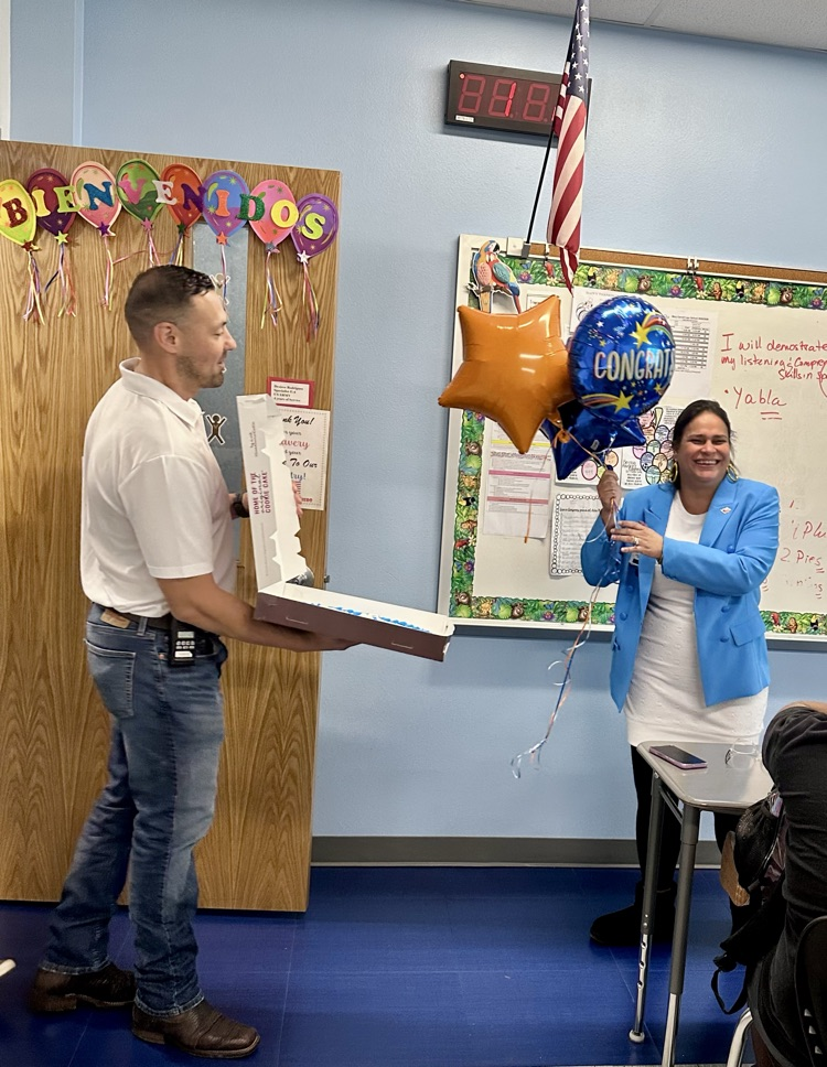 Staff celebrating Señora Rodriguez with balloons and a cookie cake in her classroom. 🎉🍪💙