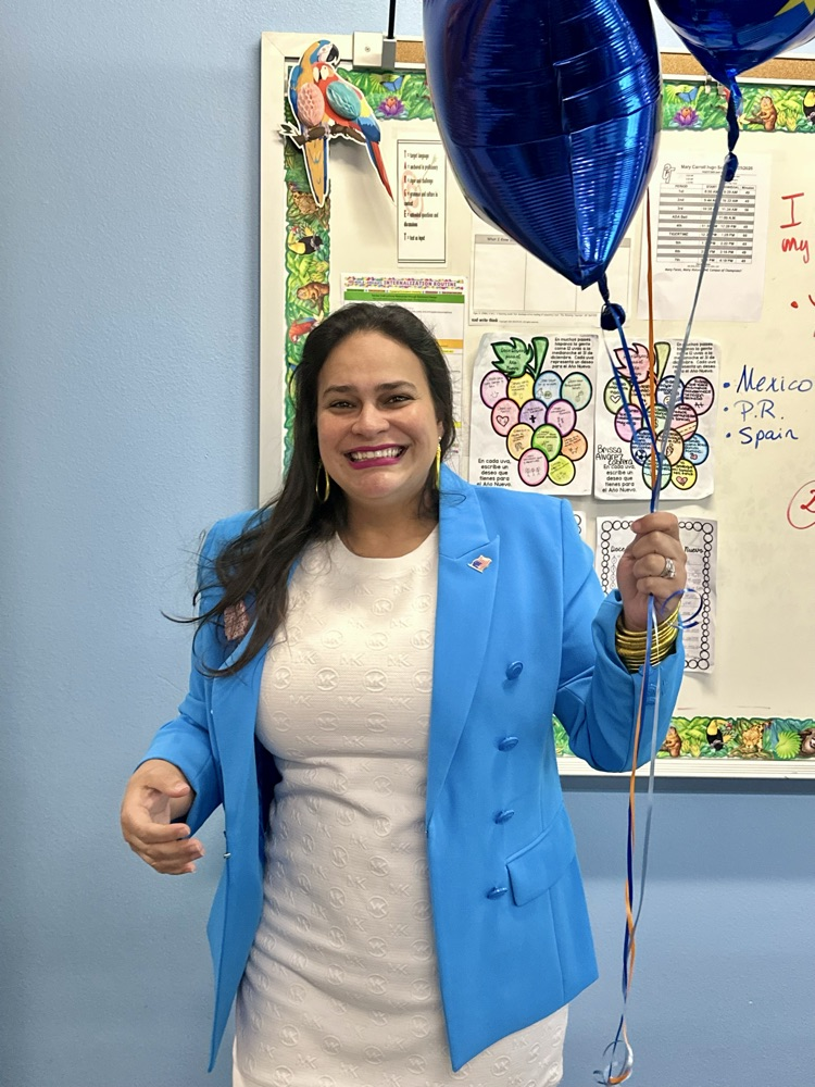Staff celebrating Señora Rodriguez with balloons and a cookie cake in her classroom. 🎉🍪💙