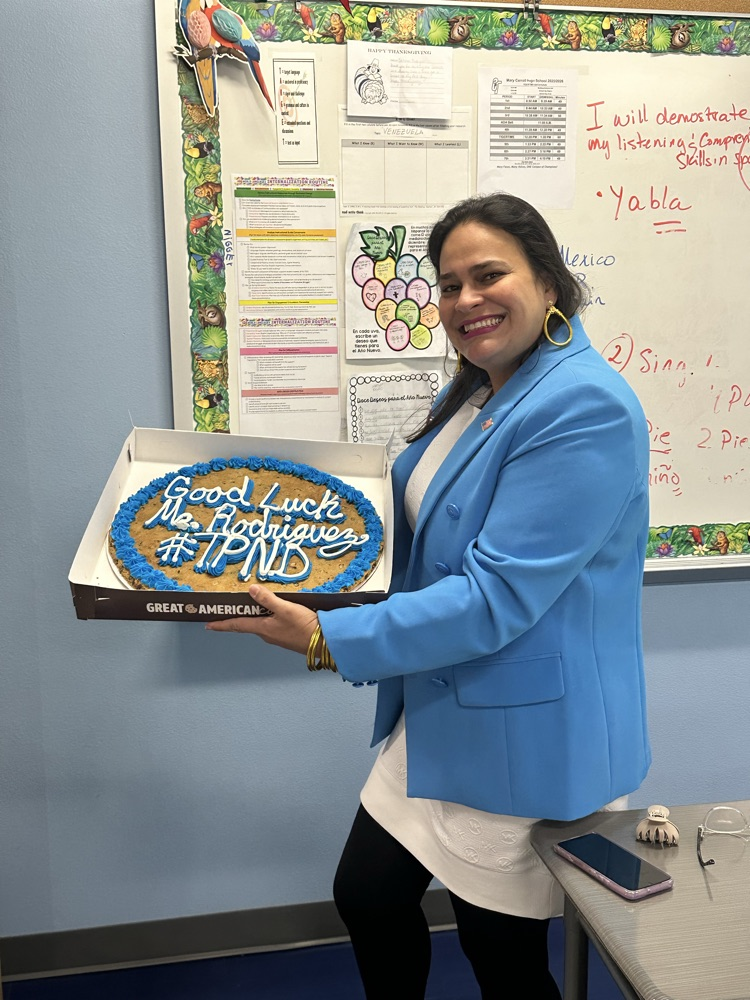 Staff celebrating Señora Rodriguez with balloons and a cookie cake in her classroom. 🎉🍪💙