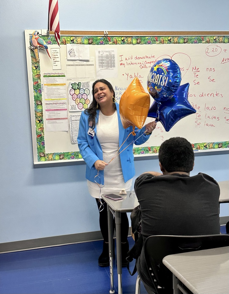Staff celebrating Señora Rodriguez with balloons and a cookie cake in her classroom. 🎉🍪💙