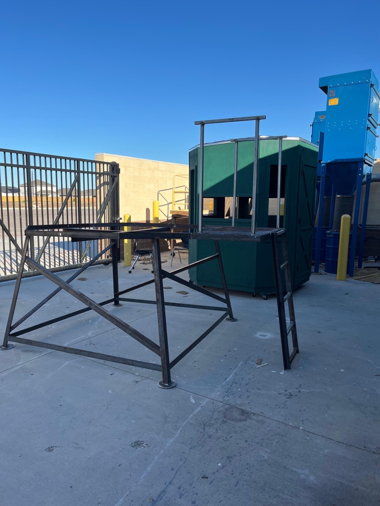 Alt text: A newly constructed metal stand supporting a green deer blind, built by student welders on campus, shown from multiple angles outdoors with clear blue skies and welding equipment nearby.