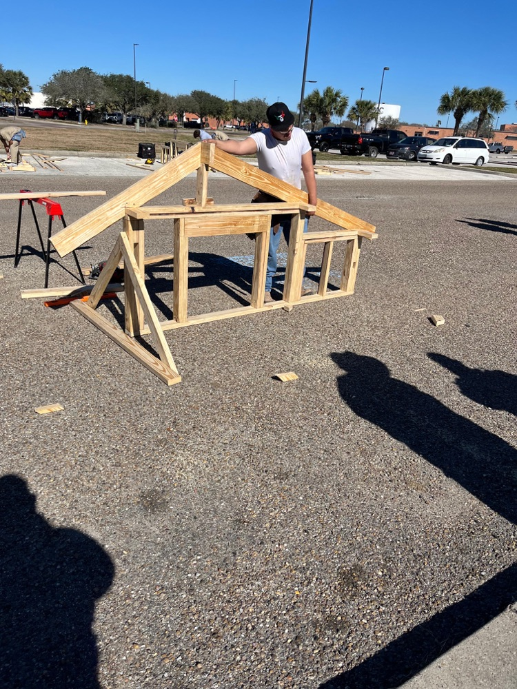 Alt text: Carroll students building wood framing projects outdoors at the District SkillsUSA competition while competing for a spot at state.