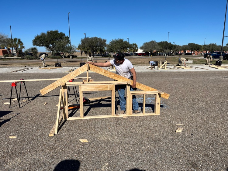 Alt text: Carroll students building wood framing projects outdoors at the District SkillsUSA competition while competing for a spot at state.