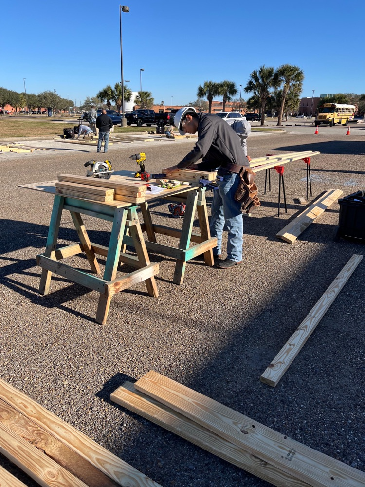 Alt text: Carroll students building wood framing projects outdoors at the District SkillsUSA competition while competing for a spot at state.