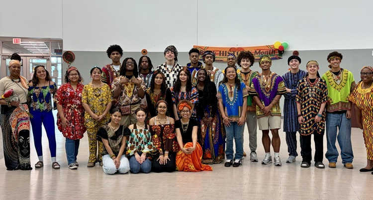 Students from the African American Culture Club modeling colorful traditional attire during a Black History Month fashion show celebration.