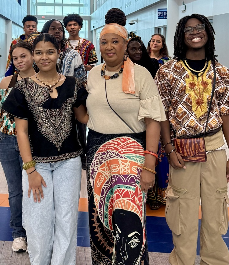 Students from the African American Culture Club modeling colorful traditional attire during a Black History Month fashion show celebration.