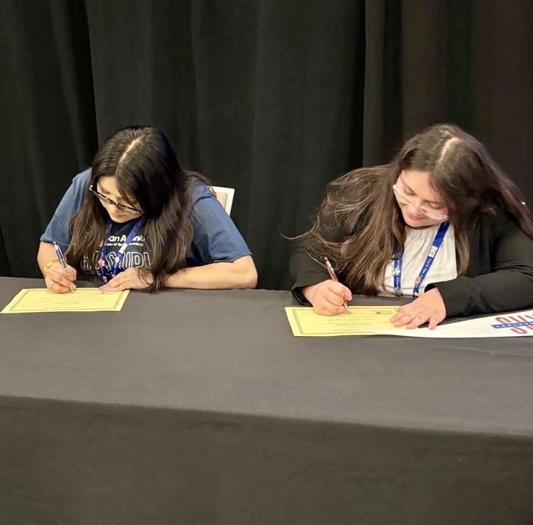 TAFE students sign college commitments as education majors at the state competition in Dallas, holding certificates and college pennants.