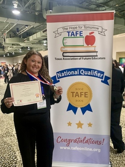 Carroll student displays medal, certificate, and project board as a TAFE Winner 