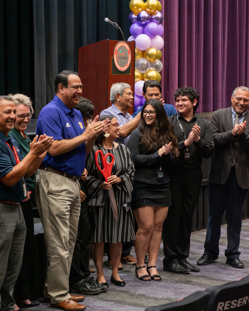 A group of people celebrating after a ribbon cutting ceremony.